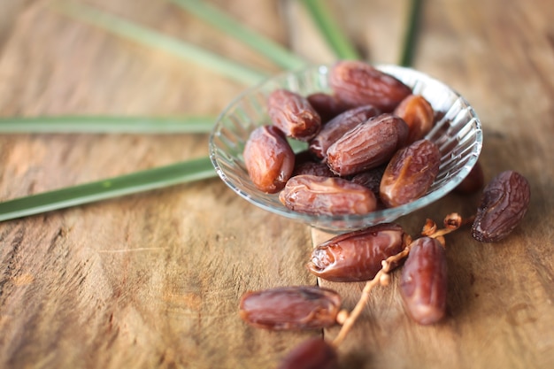 Kurma or dried dates, rosary on wooden background. 