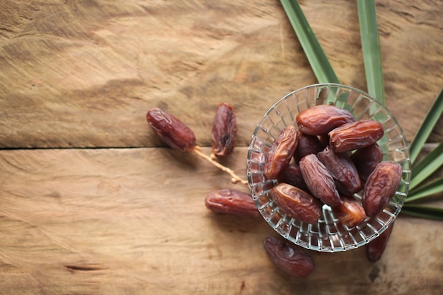 Kurma or dried dates, rosary on wooden background. 