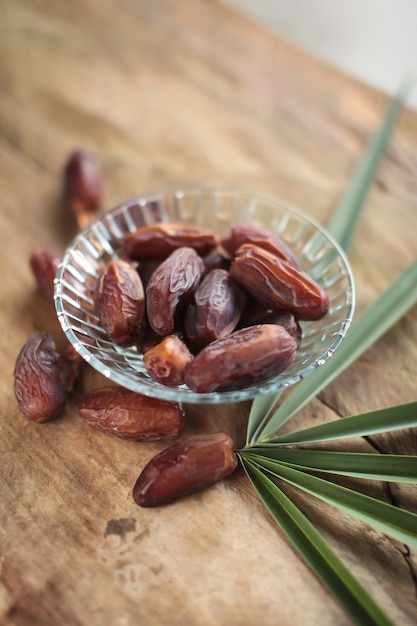 Kurma or dried dates, rosary on wooden background. 