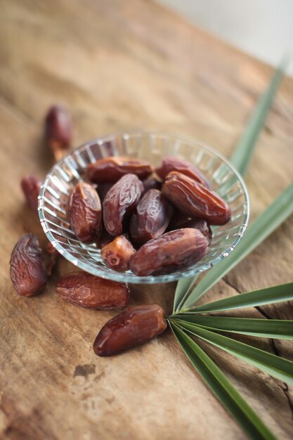 Kurma of gedroogde dadels, rozenkrans op houten achtergrond.