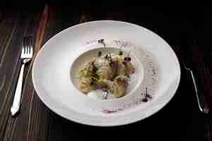 Photo kurze dish on a plate with a fork and a knife on a wooden background with spices