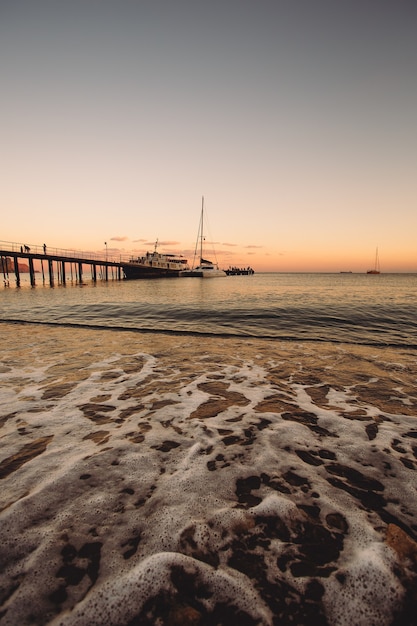 kust met jachthaven bij zonsondergang