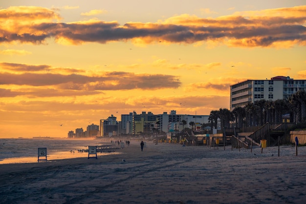 Kust van Daytona Beach in Florida bij zonsopgang met mensen en palmbomen