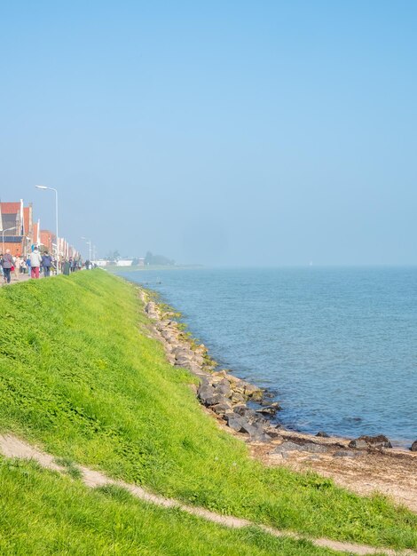 Kustlijn en strand met uitzicht op zee in Volendam, Nederland, onder de blauwe hemel