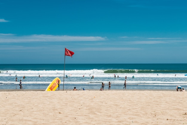 Kuta beach, bali, indonesia. Surf rescue point. Yellow rescue surfboard and red flag.