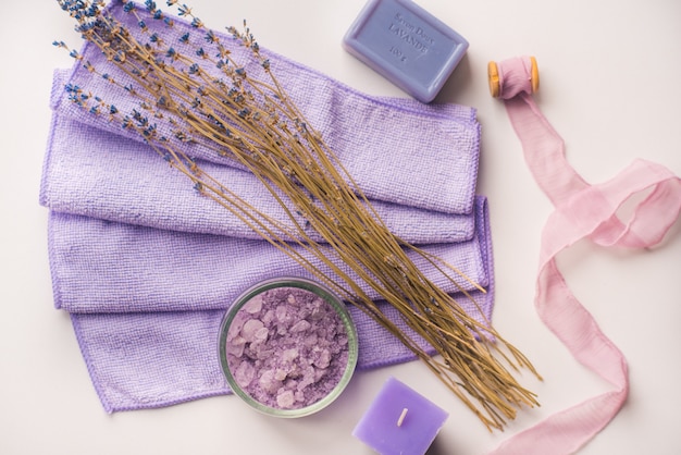 Foto kuuroordachtergrond, kaars in een schotel met zoute baden en twijgen van lavendel