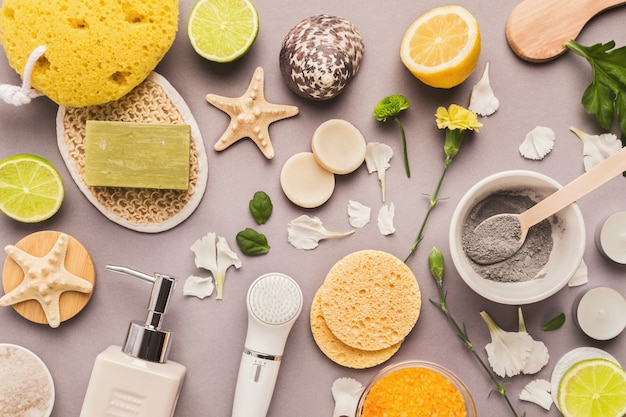 Kuuroordachtergrond. Natuurlijk zeezout en handgemaakte zeep met lotion op groene bladeren aan witte tafel. Salon of thuis lichaams- en huidverzorging, kopieer ruimte