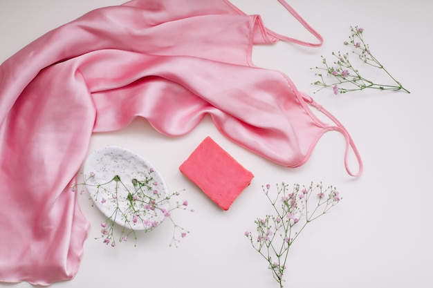 Kuuroordsamenstelling met roze zeepstaaf met ceramische de zijdestof van de zeepbak en bloemen