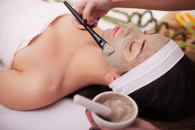 Kuuroordtherapie voor jonge vrouw die gezichtsmasker hebben bij schoonheidssalon - binnen