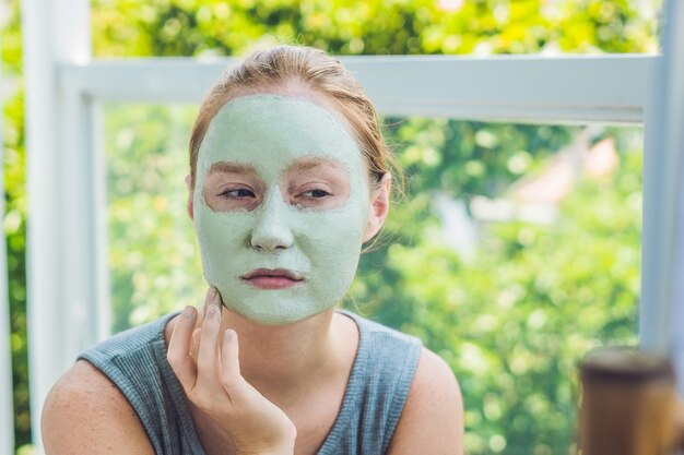 Kuuroordvrouw die Gezichts groen kleimasker toepassen