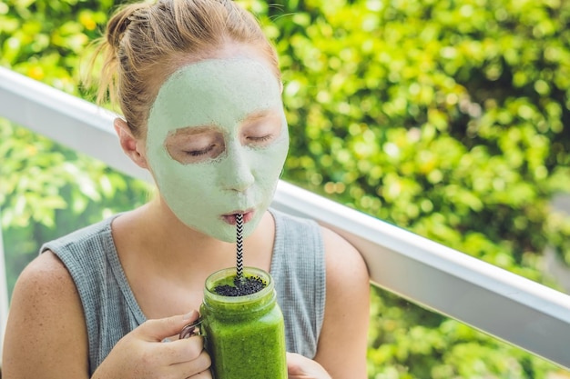 Kuuroordvrouw die Gezichtsgroen kleimasker toepast. Schoonheidsbehandelingen. Frisse groene smoothie met banaan en spinazie met hart van sesamzaadjes. Liefde voor een gezond rawfood concept. Detox-concept