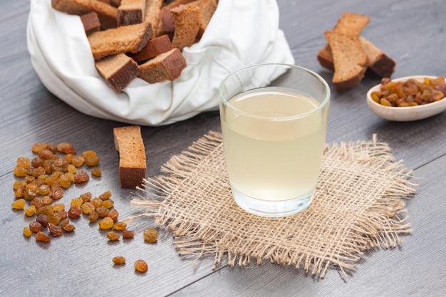 Kvas in glas met roggebrood en rozijnen op houten achtergrond