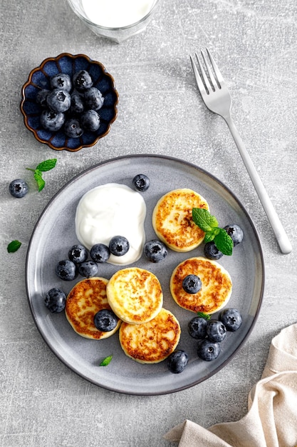 Kwarkbeignets met verse bosbessen en yoghurt voor het ontbijt van bovenaf