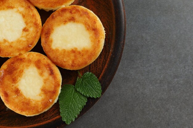 Kwarkbeignets op een bord Zoete heerlijke kwarkpannenkoekjes