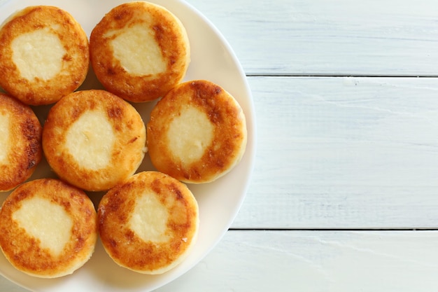 Kwarkbeignets op een bord Zoete heerlijke kwarkpannenkoekjes