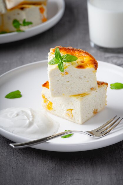 Kwarkbraadpan met gedroogde abrikozenvulling met rozijnen op plaat op houten tafel