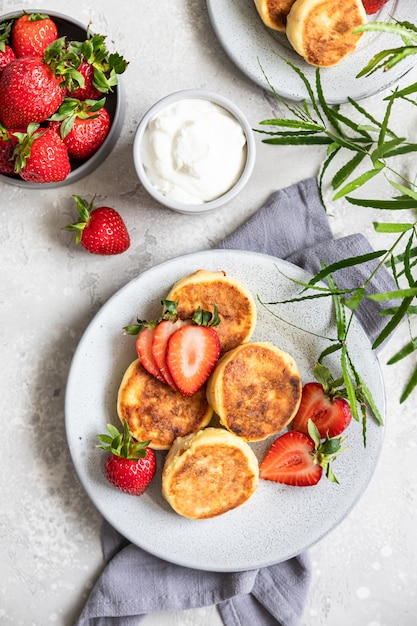 Kwarkpannenkoekjes of beignets met aardbei en natuurlijke yoghurt Syrniki