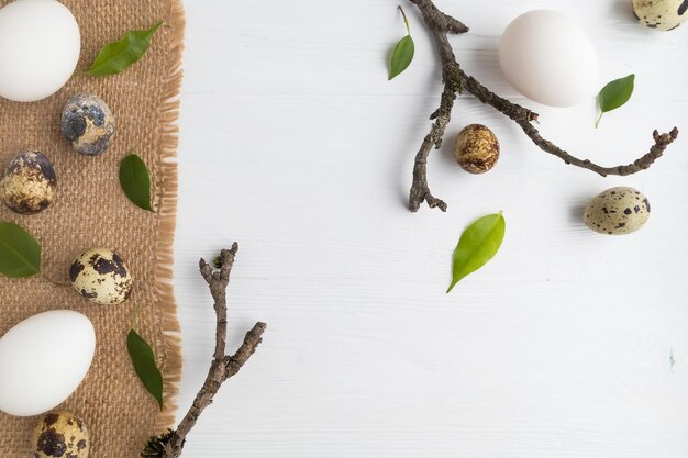 Kwartel en kippeneieren in een mand en op een linnen servet op een witte achtergrond met ruimte voor tekst Het concept van Pasen