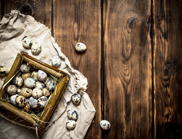 Kwarteleitjes in mand op houten tafel.