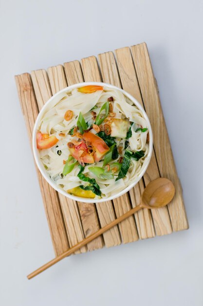 Kwetiau served in a paper bowl Placed on the tray