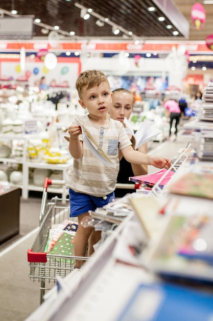 KYIV JAN 6 2019 Little boy choosing school supplies with mother in stationery shop