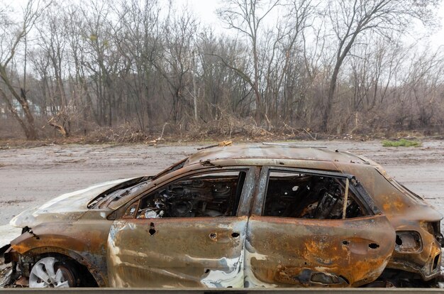 KYIV REG UKRAINE Apr 02 2022 A destroyed and burnt cars seen on a KyivZhytomyr highway 20 km from Kyiv