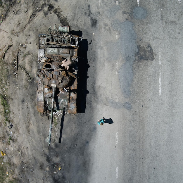 Kyiv region Ukraine May 15 2022 War in Ukraine Highway Kyiv Zhytomyr People take selfies against destroyed russian tank after russian atack in Febrary