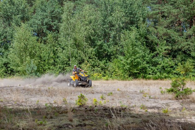 写真 キエフ 2019 砂の森で黄色のクワッド atv 全地形万能車に乗っている男エクストリーム スポーツ モーション アドベンチャー観光名所