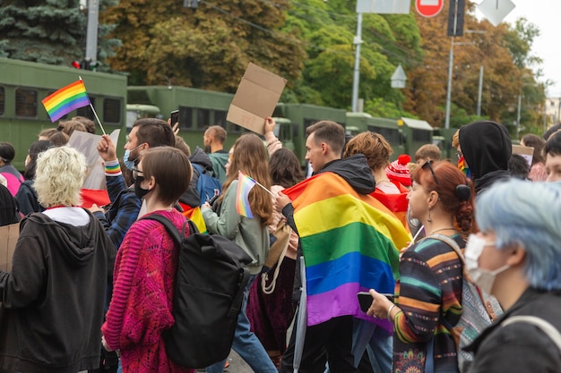 Kyiv, Ukraine - 09.19.2021: LGBTQ community at the Pride Parade. Participants of the march with rainbow symbols against the background of special police cars.