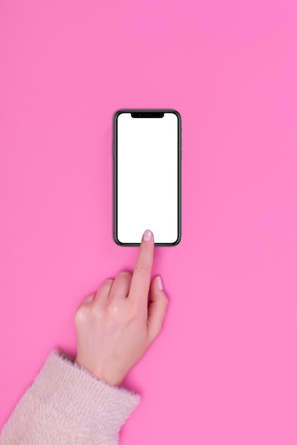 Kyiv, Ukraine, 2019-09-25. Top view of a woman hand using IPhone 11 on pink background.