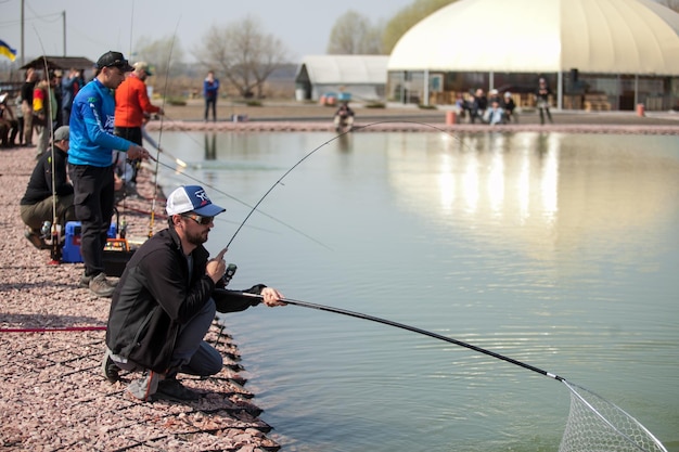 KYIV, UKRAINE - APRIL 16, 2018 Sport fishing tournament, male fishermen catch fish in the lake
