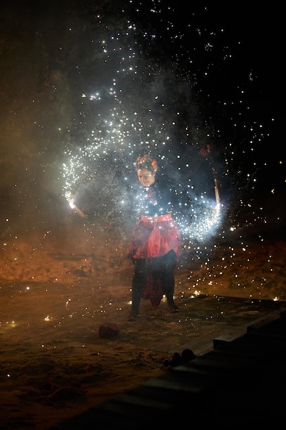 Foto kiev ucraina 21 febbraio 2021 donna spettacolo di fuoco con fuochi d'artificio nelle sue mani che girano poi