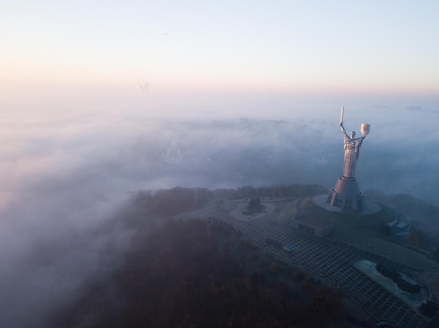 写真 キエフウクライナ2018年11月10日ドニエプル川からの霧で早朝にキエフの母祖国の像の航空写真ウクライナ