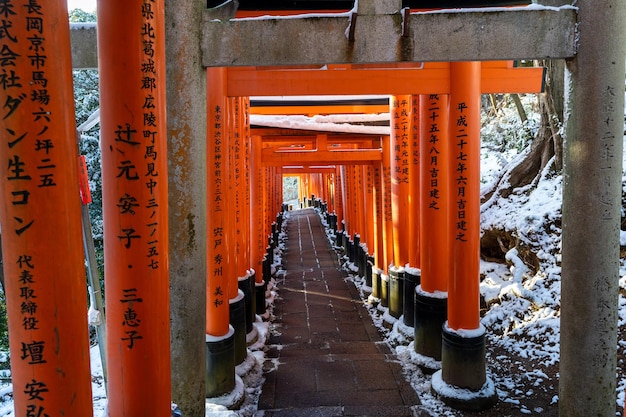 京都府 2023 年 1 月 24 日 伏見稲荷大社冬の屋根に雪が降る鳥居