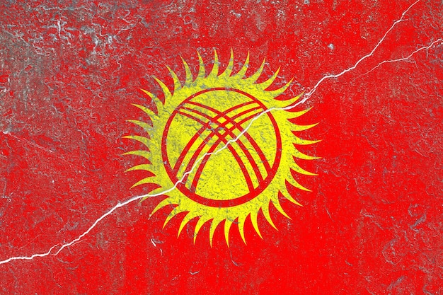 Foto bandiera del kirghizistan dipinta su un vecchio muro di cemento incrinato