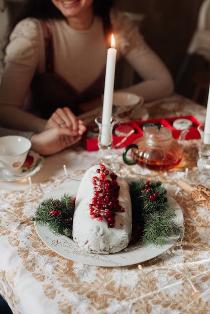 L festive table close-up christmas stollen and girl at the table