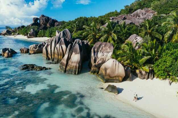 "La digue" island in Seychelles. Silver beach with granitic stone, and jungle. Man enjoying vacations and relaxing on the beach. Aerial view