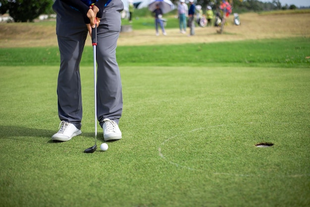 Laag gedeelte van de man die golf speelt op het gras