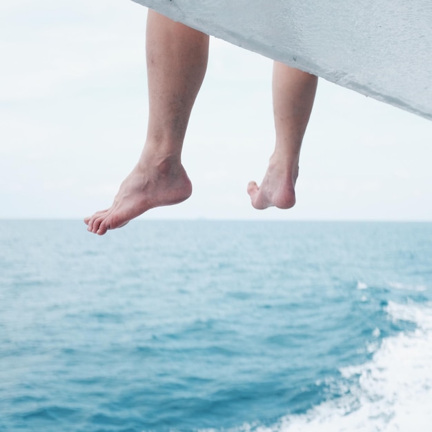 Laag gedeelte van de man die over de zee zit