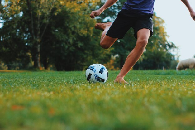 Foto laag gedeelte van de man die voetbal speelt op het veld