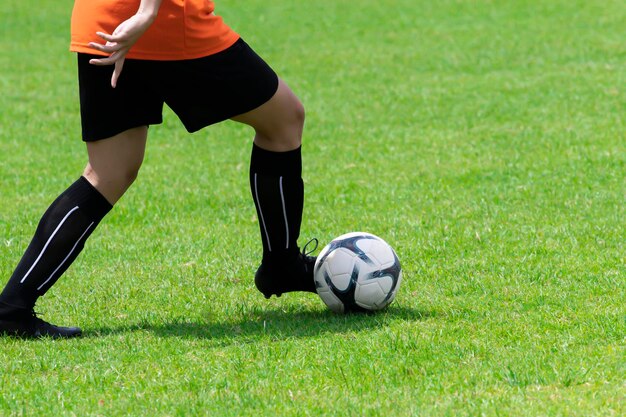 Foto laag gedeelte van de man die voetbal speelt op het veld