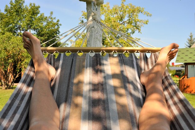 Foto laag gedeelte van de man op een hangmat tegen de lucht