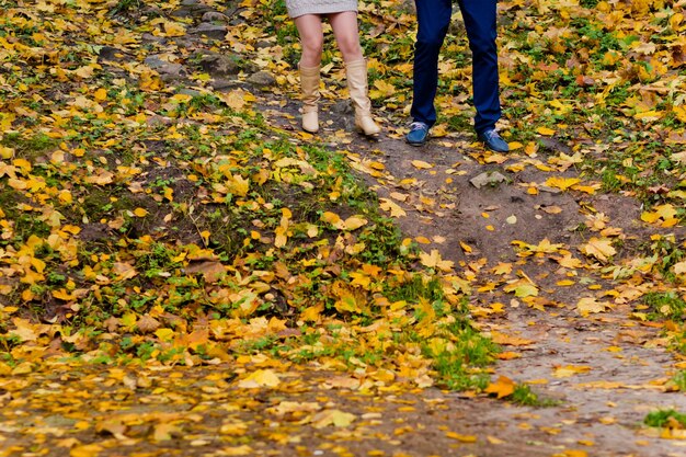 Foto laag gedeelte van een echtpaar dat in de herfst op het veld loopt