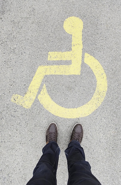 Foto laag gedeelte van een man die bij een bord op de weg staat