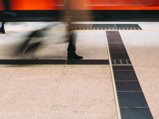 Foto laag gedeelte van een man die op het perron van het treinstation loopt