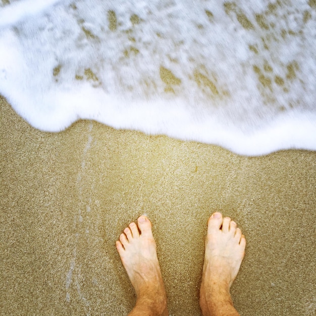 Laag gedeelte van een man die op het strand staat