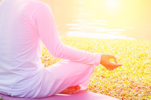 Foto laag gedeelte van een man die yoga doet terwijl hij op het gras in het park zit