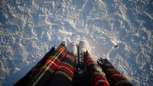 Foto laag gedeelte van een persoon die op een met sneeuw bedekt veld staat