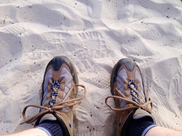 Laag gedeelte van een persoon die op een zandstrand staat