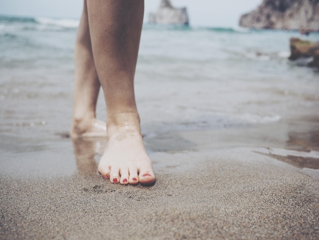 Laag gedeelte van een vrouw die op een natte kust staat
